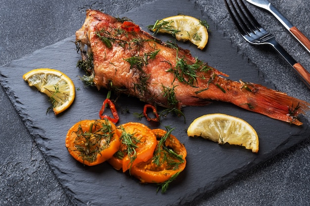 Baked sea bass with tomato pepper lemon and herbs