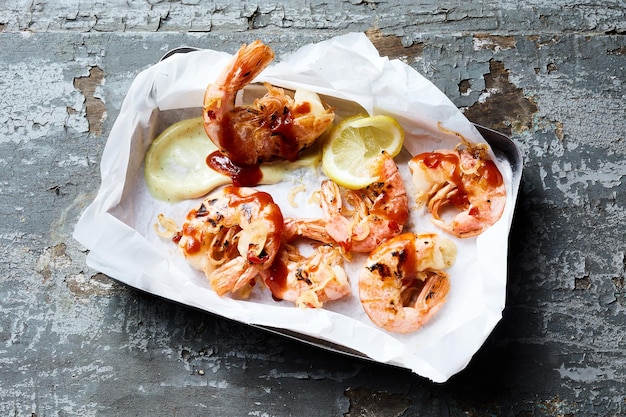 Baked shrimps with lemons on table