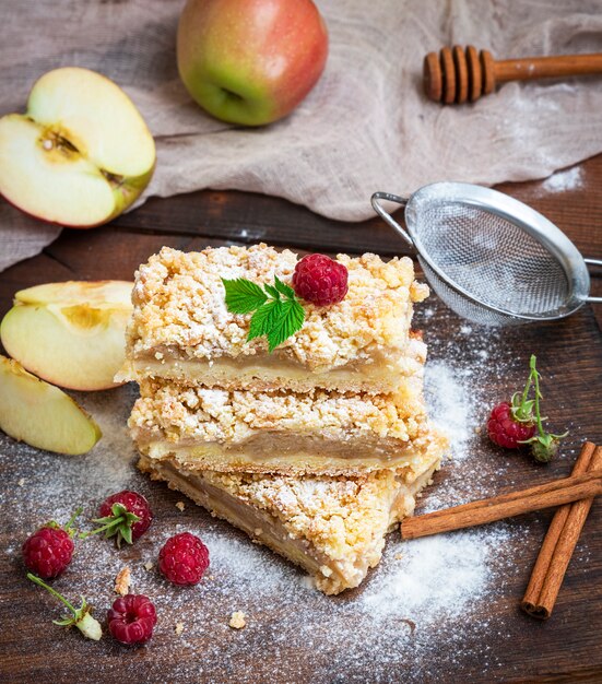  baked slices of pie with apples on a brown wooden board