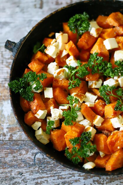 Baked slices of pumpkin with slices of white cheese. Warm salad with pumpkin and feta cheese. Vegetarian food. Healthy eating