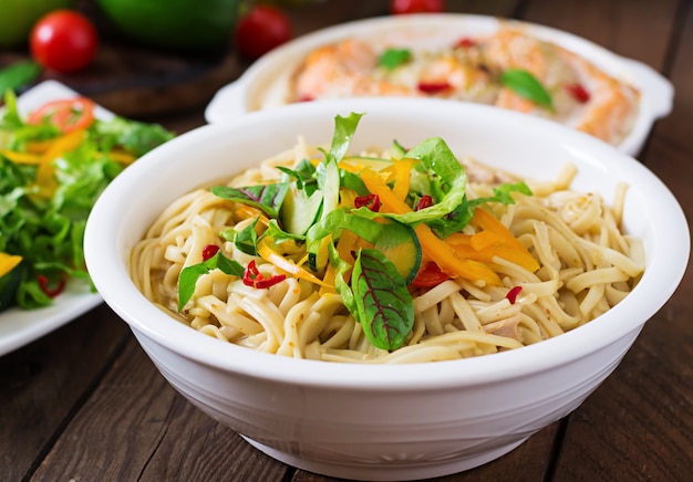 Baked slices of red and white fish with honey and lime juice, served with fresh salad and soft noodles in miso broth