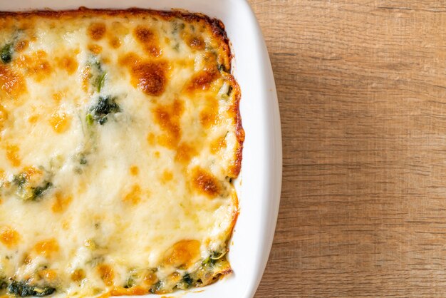 baked spinach lasagna with cheese in white plate