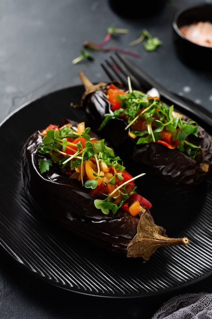 사진 검은 돌 또는 콘크리트 테이블에 다른 야채, 토마토, 후추, 양파 및 파슬리로 구운 박제 가지