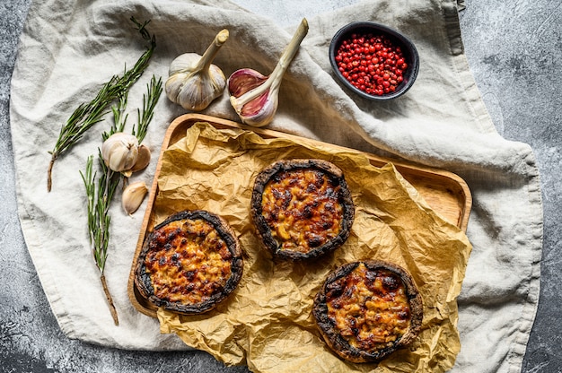 Baked stuffed Portobello mushrooms. Gray background. Top view