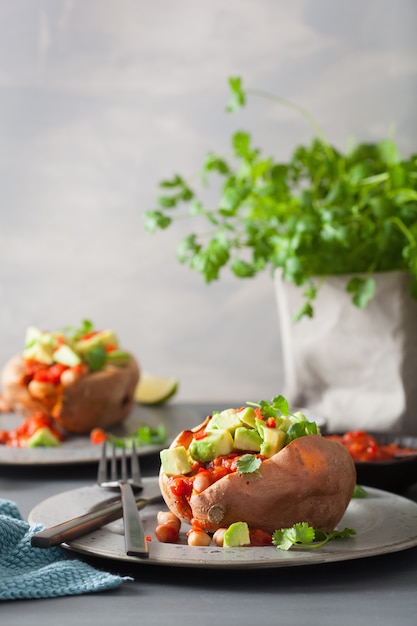 Baked sweet potatoes with avocado chili salsa and beans