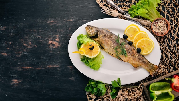 Baked Trout with Vegetables On the old wooden background Free space for text Top view