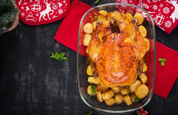 Baked turkey or chicken The Christmas table is served with a turkey decorated with bright tinsel Fried chicken table Christmas dinner Top view above