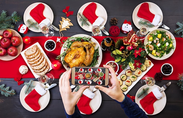 Baked turkey Christmas dinner The Christmas table is served with a turkey decorated with bright tinsel and candles Fried chicken table Family dinner Top view