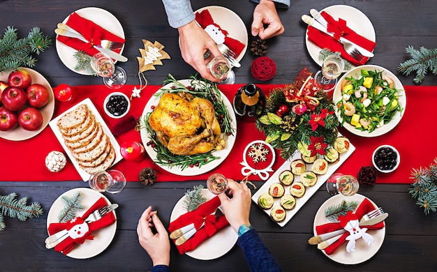 Tacchino al forno il tavolo di natale è servito con un tacchino, decorato con tinsel luminoso