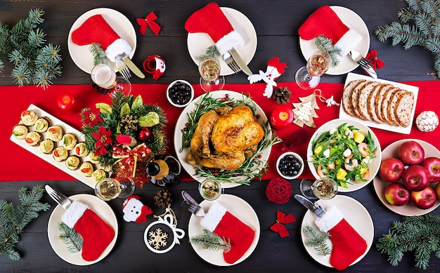 Tacchino al forno il tavolo di natale è servito con un tacchino, decorato con tinsel luminoso