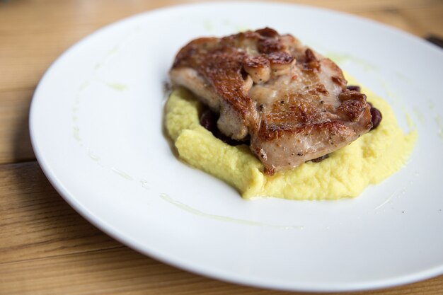 Baked turkey meat and mashed potatoes on a white plate