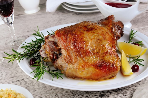 Baked turkey thigh, on the table with cranberry sauce