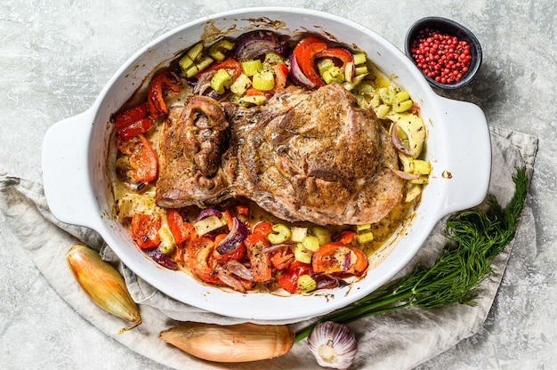 Baked Turkey thigh with vegetables in a baking dish. Top view