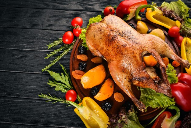 Tacchino al forno con verdure e spezie giorno del ringraziamento griglia di pollo d'oca su sfondo di legno vista dall'alto