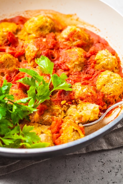 Baked vegan bean meatballs in tomato sauce in the pan.