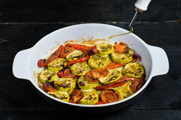 Baked vegetables in baking dish, zucchini, bell pepper and zucchini.