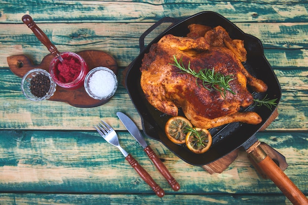 Baked whole chicken with apples in pan