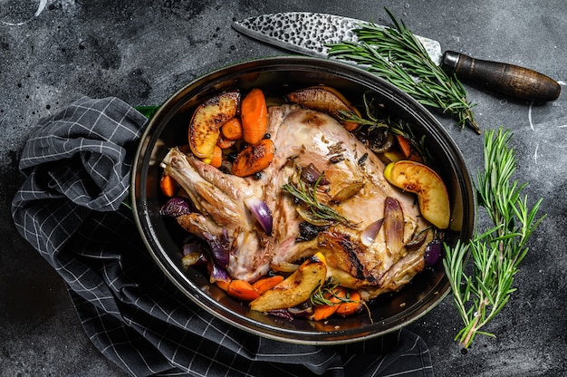 Baked whole lamb shoulder leg in a baking dish.