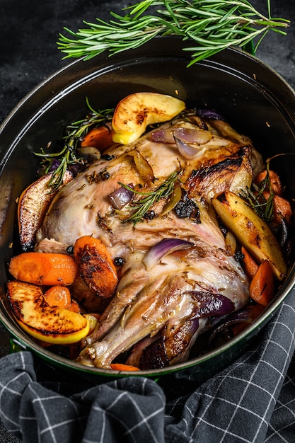 Photo baked whole lamb shoulder leg in a baking dish