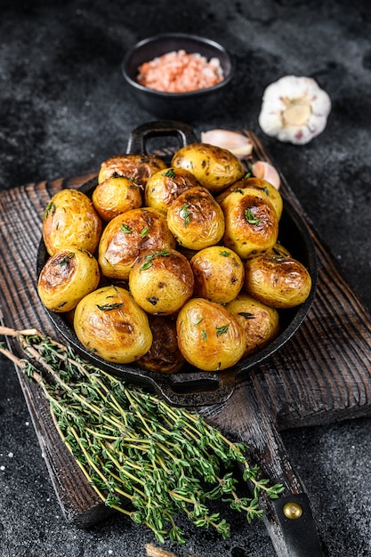 Baked youg potato with thyme in a pan