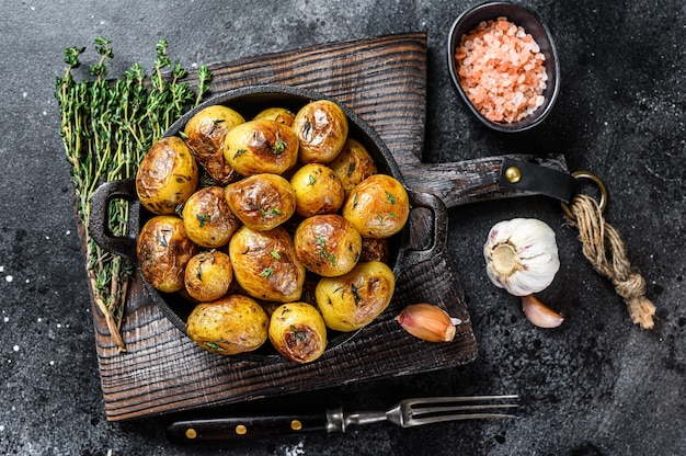 Baked youg potato with thyme in a pan