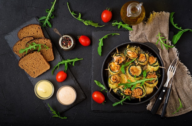 Baked zucchini rolls with cheese, carrot and chicken breast. flat lay. top view