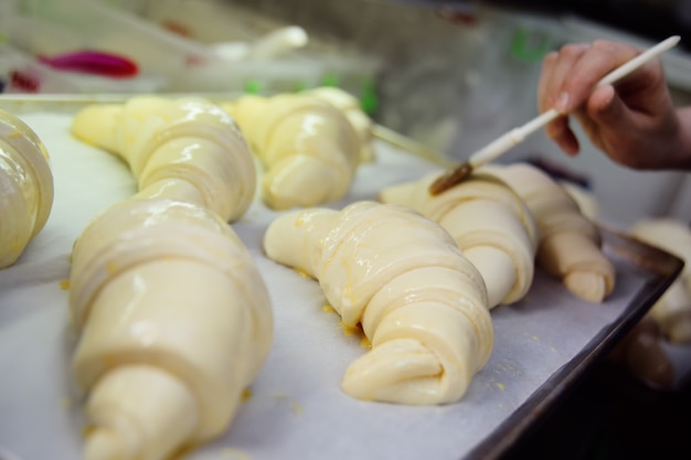 焼く前にクローズアップで生のクロワッサンを焼くパン屋