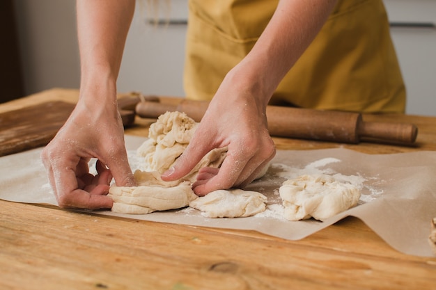 Un fornaio o uno specialista culinario scolpisce un prodotto dall'impasto. avvicinamento.