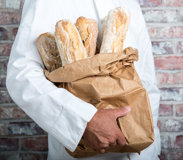 Baker dat traditionele brood Franse baguettes houdt