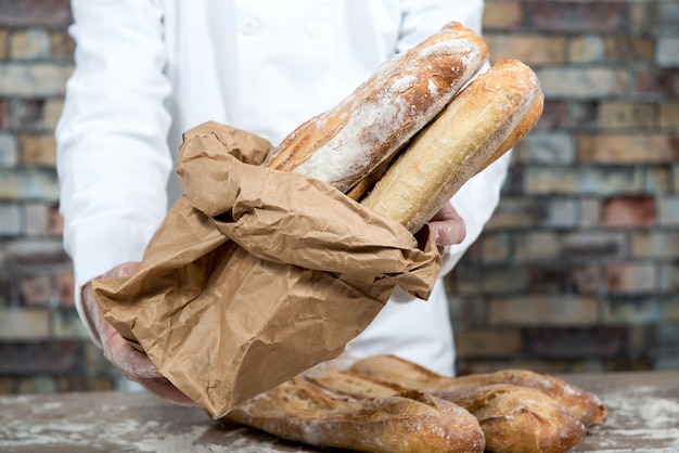 Baker dat traditionele brood Franse baguettes houdt