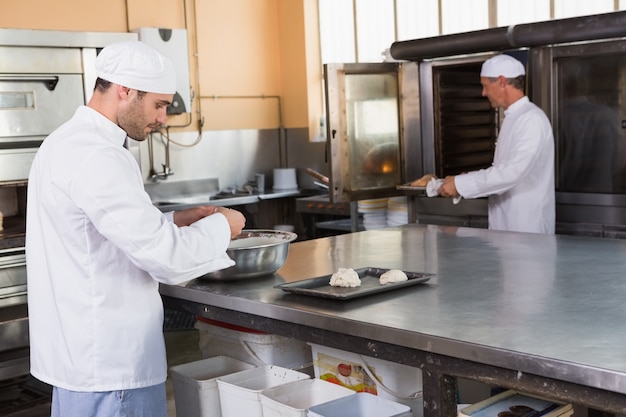 Foto baker die deeg in het mengen van kom maken