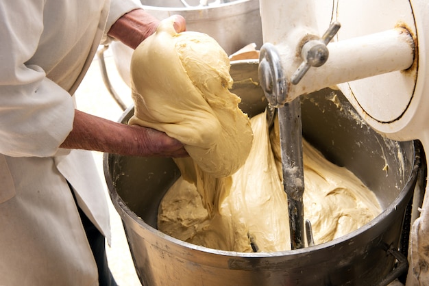 Baker die een hoop ruw deeg in zijn handen houdt