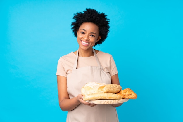 Baker girl catching breads over blue background