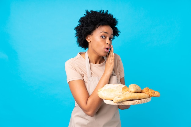 Baker girl catching breads over blue background