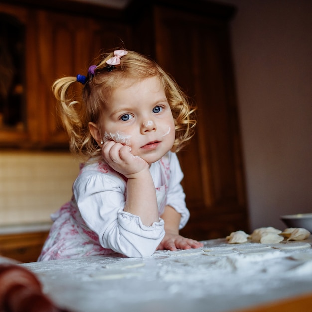 baker girl in chef hat at kitchen