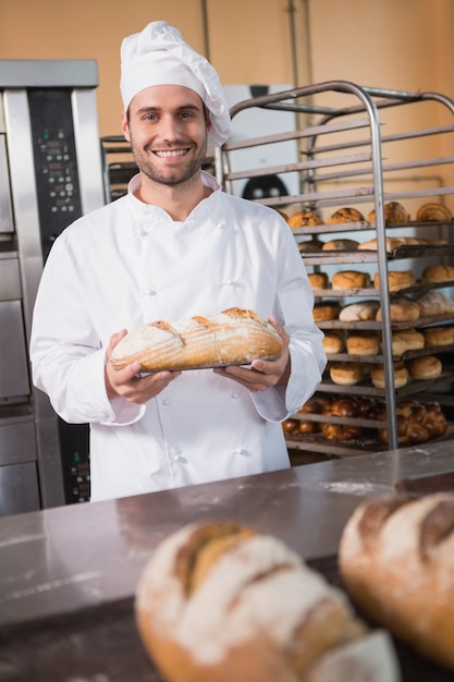 Baker holding freshly baked bread