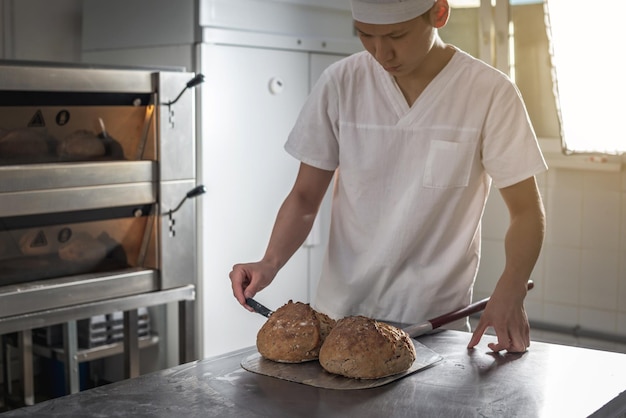 The baker is a man in the process of baking bread Production of bakery products as a small business