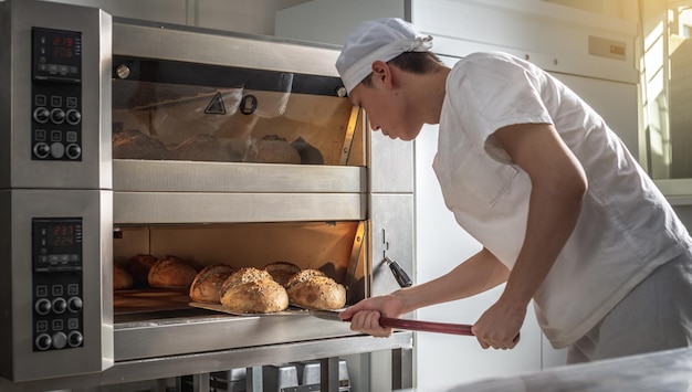 パン職人は、パンを焼いている最中の男性です。中小企業としてのベーカリー製品の生産