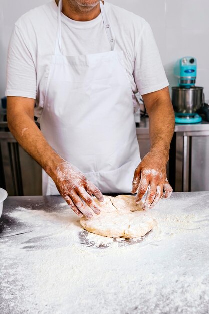 Baker kneading flour for bread making