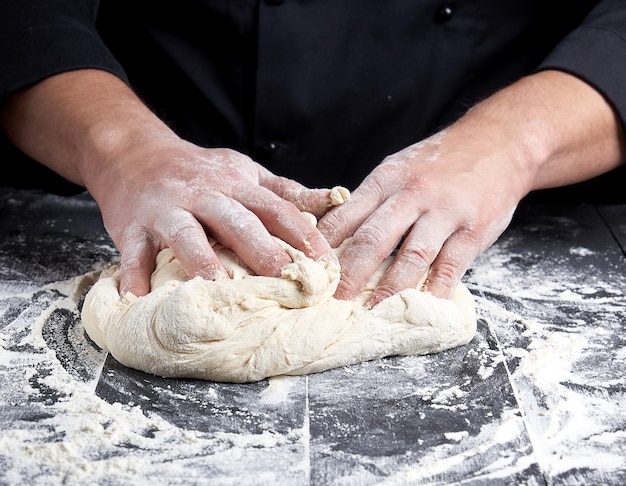 Baker kneads wheat flour dough 