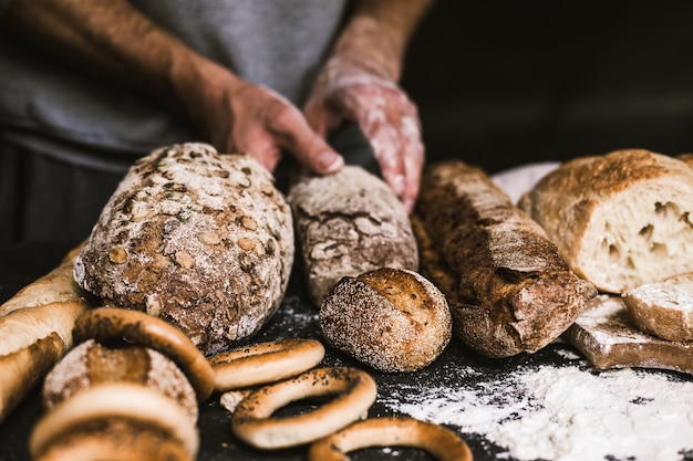 Baker man holding a rustic organic loaf of bread in his hands