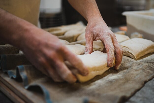 Baker man placing bread dough on couche cloth to rest Artisan bakery