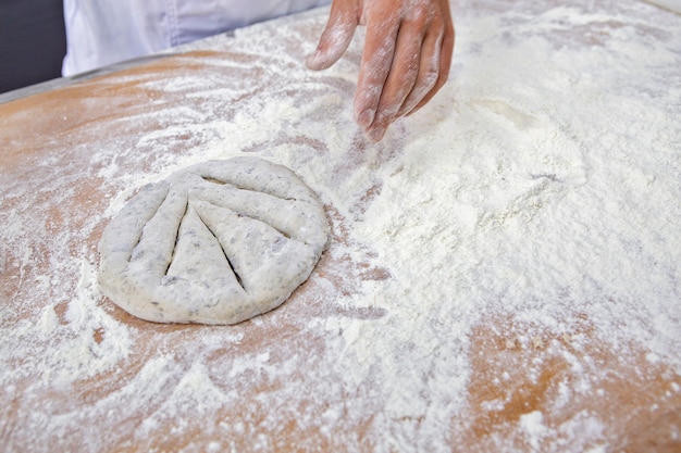 Foto baker che modella i pani integrali della farina per cuocere