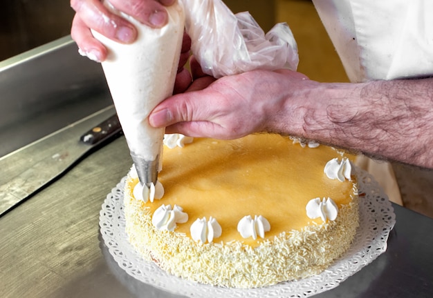 Baker piping cream decoraties op een cake