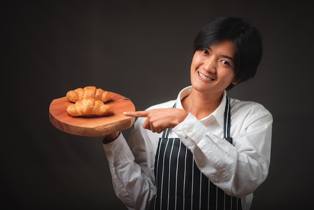 퍼프 페이스 트리로 만든 카페에서 갓 구운 크루아상을 선물하는 베이커는 맛있는 프랑스 빵집 컨셉을 찾고 있습니다.