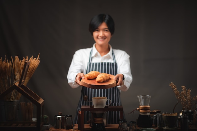 Baker presenting freshly baked croissants in cafe