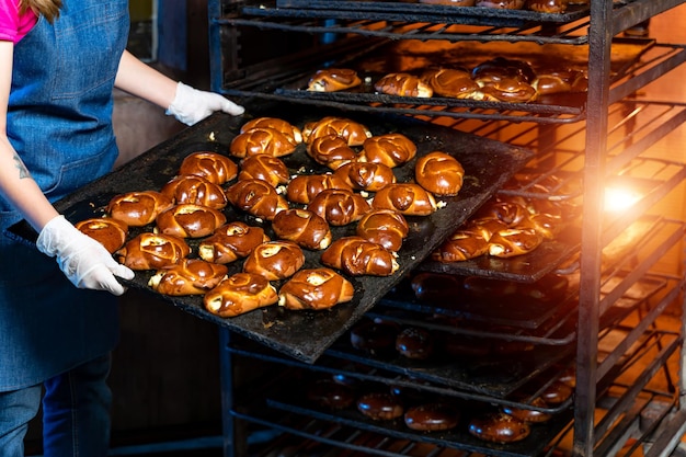 Baker presenting tray with pastry or dough in bakery