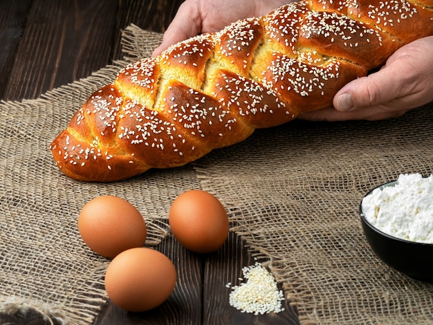 Baker mette il pane intrecciato di pasqua sul tavolo