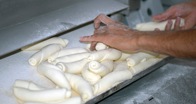 The baker shapes the bread to be baked