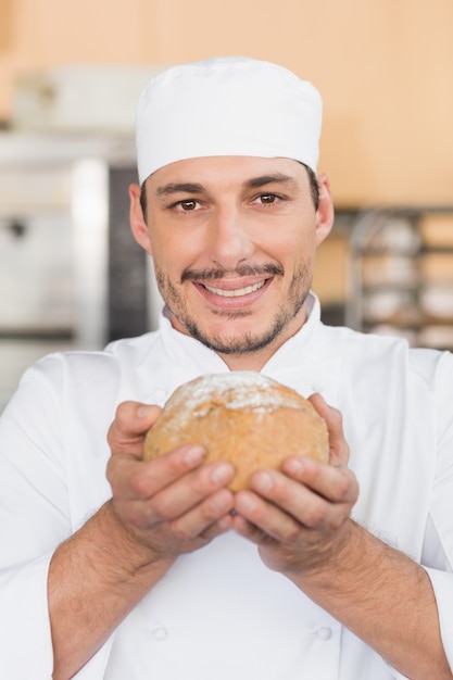 Baker smelling a freshly baked loaf